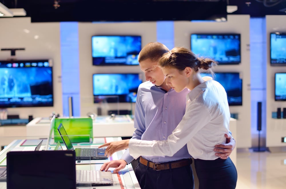 people in consumer electronics  retail store looking at latest laptop, television and photo camera to buy